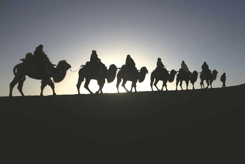 Pelancong menunggang unta di tapak peranginan Gunung Mingsha dan Mata Air Yueya di Dunhuang, provinsi Gansu, pada 15 Februari. (Xinhua/Zhang Xiaolong)