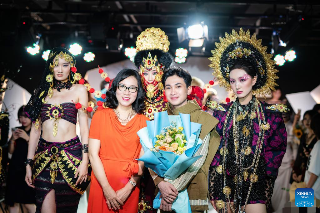 Yusuf Maulana Firdaus (depan kanan), pelajar antarabangsa dari Jakarta, Indonesia, bergambar dengan gurunya Huang Yanbing (depan kiri) dalam kalangan model fesyen di Nanning, ibu kota Wilayah Autonomi Zhuang Guangxi, selatan China, 17 Jun 2023. (Xinhua)