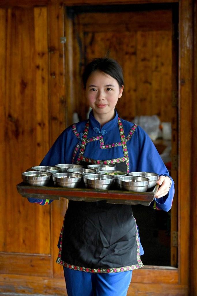 Seorang penduduk kampung menghidangkan teh minyak untuk tetamu di Kampung Bunong di Weijiang di Kaunti Longsheng, Wilayah Autonomi Guangxi Zhuang di selatan China, 26 Jun 2024. (Xinhua/Huang Bohan)