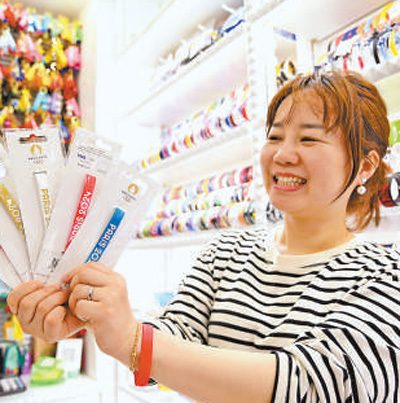 Seorang pemilik kedai menunjukkan gelang silikon dengan logo Sukan Olimpik Paris di Pasar Perdagangan Antarabangsa Yiwu di bandar Yiwu, Provinsi Zhejiang, timur China (People's Daily/Wu Fengyu).